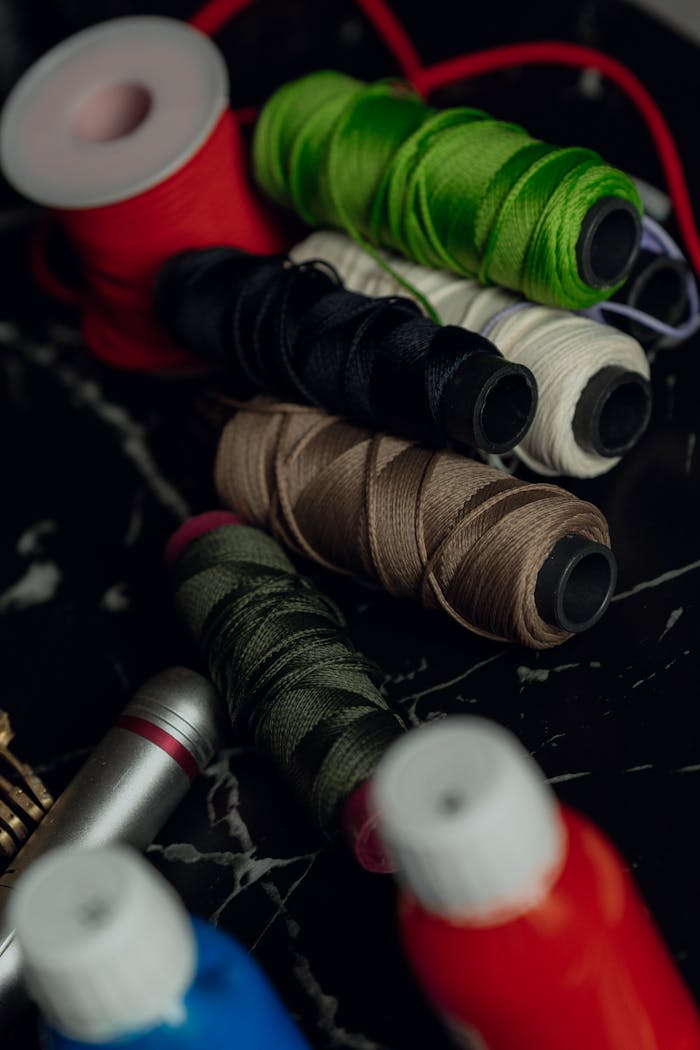 A variety of colorful sewing threads displayed on a marble surface, perfect for crafting and sewing projects.